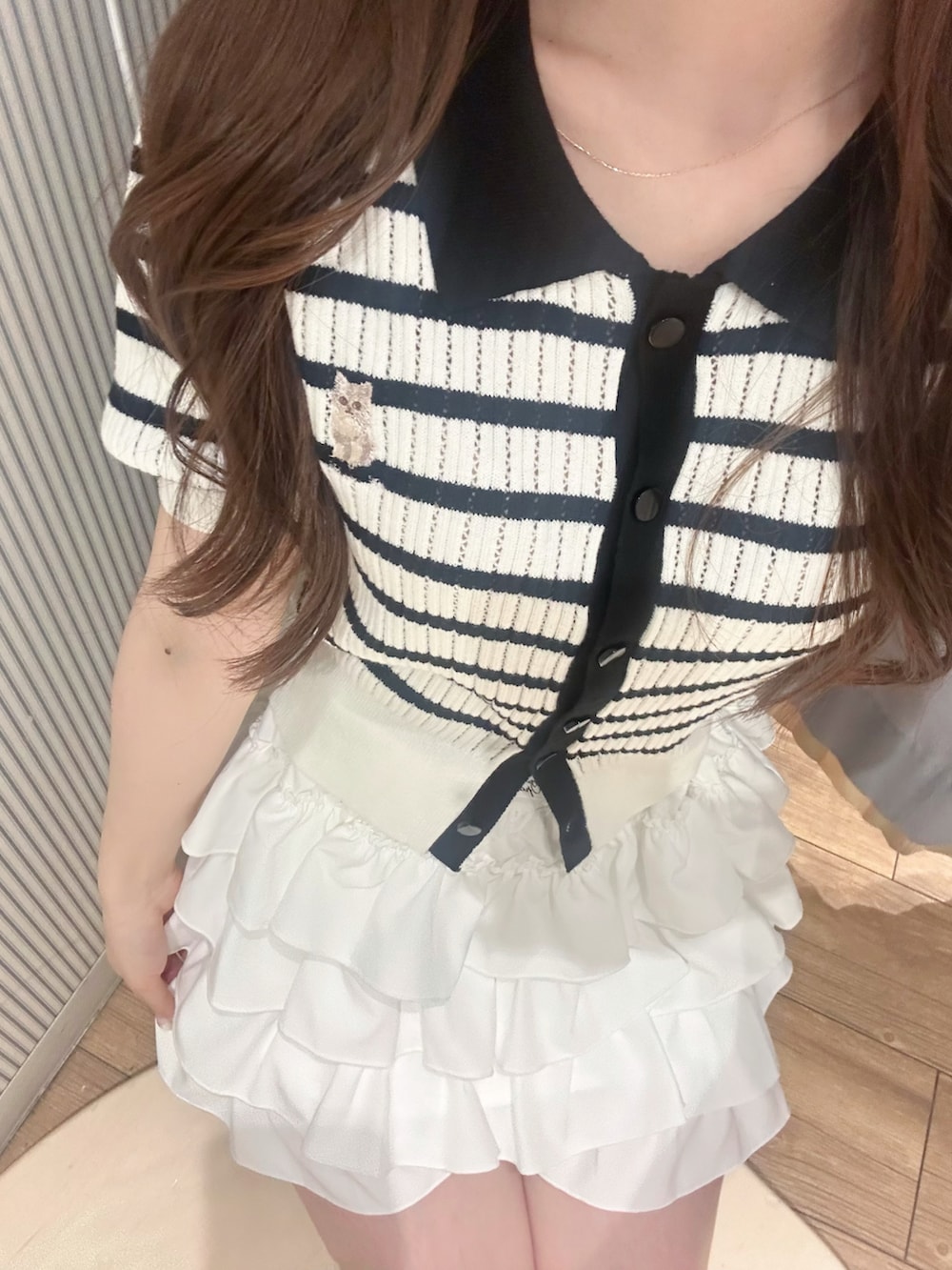 その他のポロシャツ、ホワイト系のスカート、ホワイト系のショルダーバッグを着用したレディースの夏コーディネートの4枚目の写真