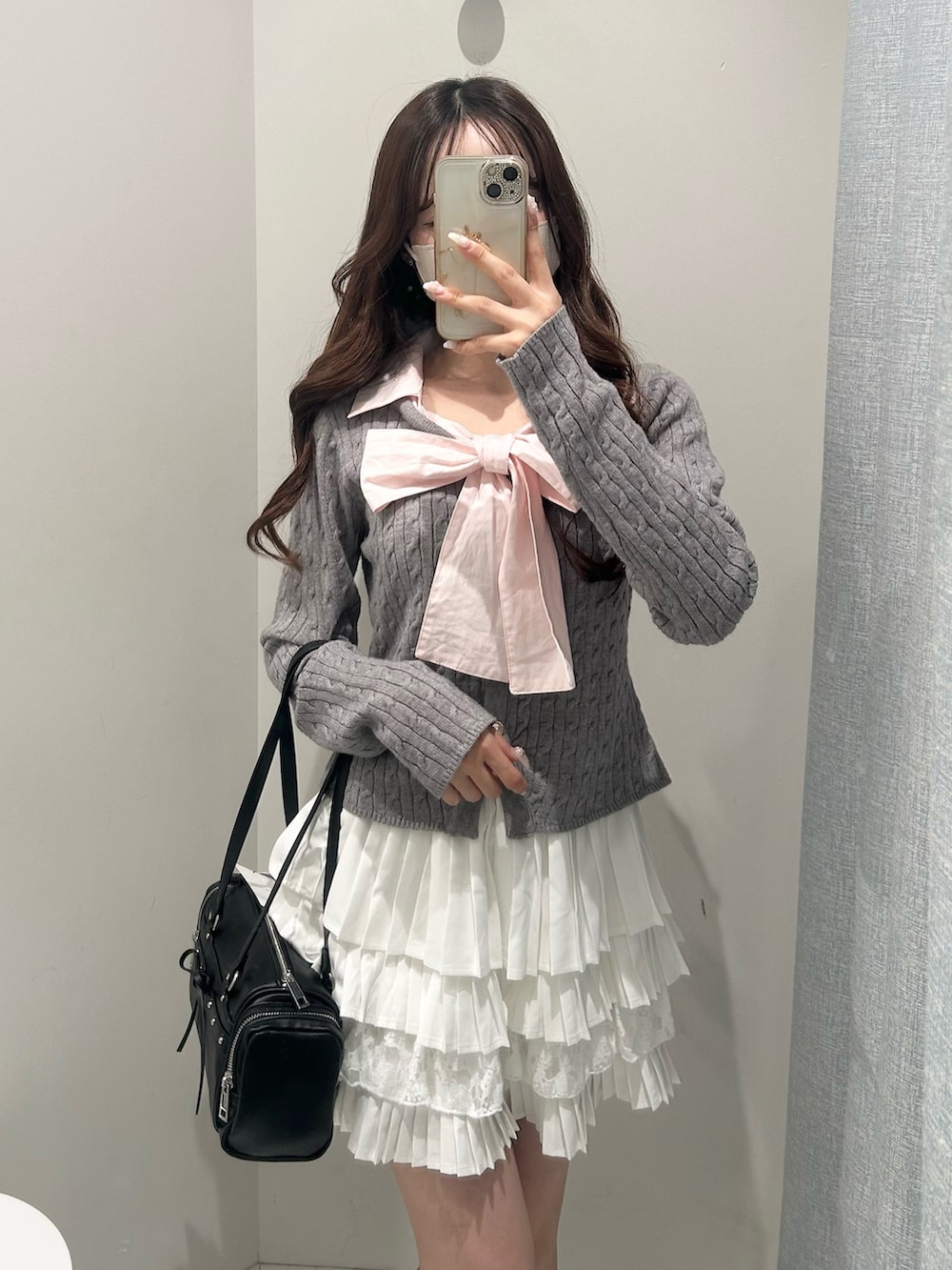 ブラック系のトートバッグ、ホワイト系のスカート、グレー系のニット/セーターを着用したレディースの冬コーディネートの2枚目の写真