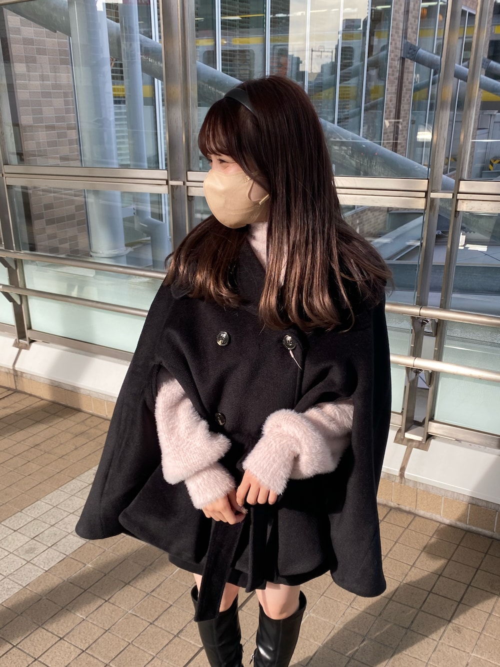 ブラック系のブーツ、ブラック系のポンチョ、ピンク系のニット/セーターを着用したレディースの冬コーディネートの5枚目の写真
