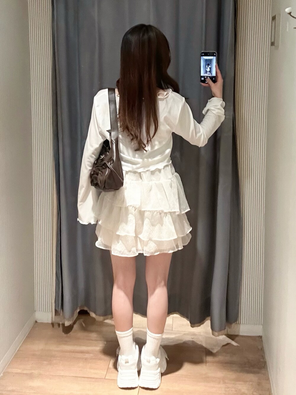 ホワイト系のスニーカー、ホワイト系のワンピース、ブラウン系のショルダーバッグを着用したレディースの春コーディネートの4枚目の写真
