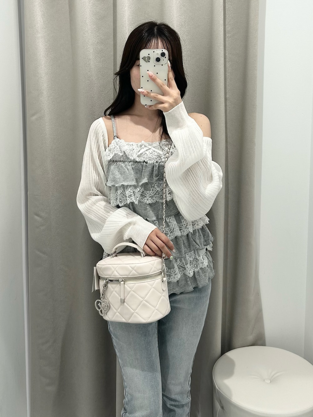 ブルー系のデニムパンツ、ホワイト系のドレスシューズ、ホワイト系のショルダーバッグを着用したレディースの春コーディネートの4枚目の写真