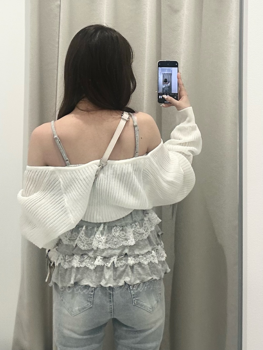 ブルー系のデニムパンツ、ホワイト系のドレスシューズ、ホワイト系のショルダーバッグを着用したレディースの春コーディネートの5枚目の写真