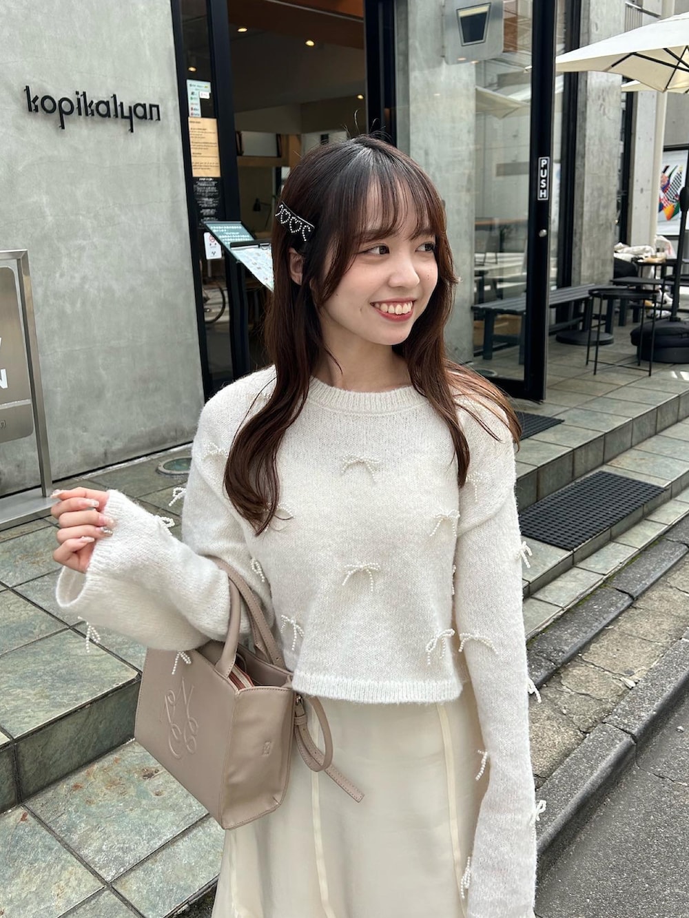 ホワイト系のスカート、ホワイト系のバレエシューズ、ホワイト系のニット/セーターを着用したレディースの秋コーディネートの2枚目の写真