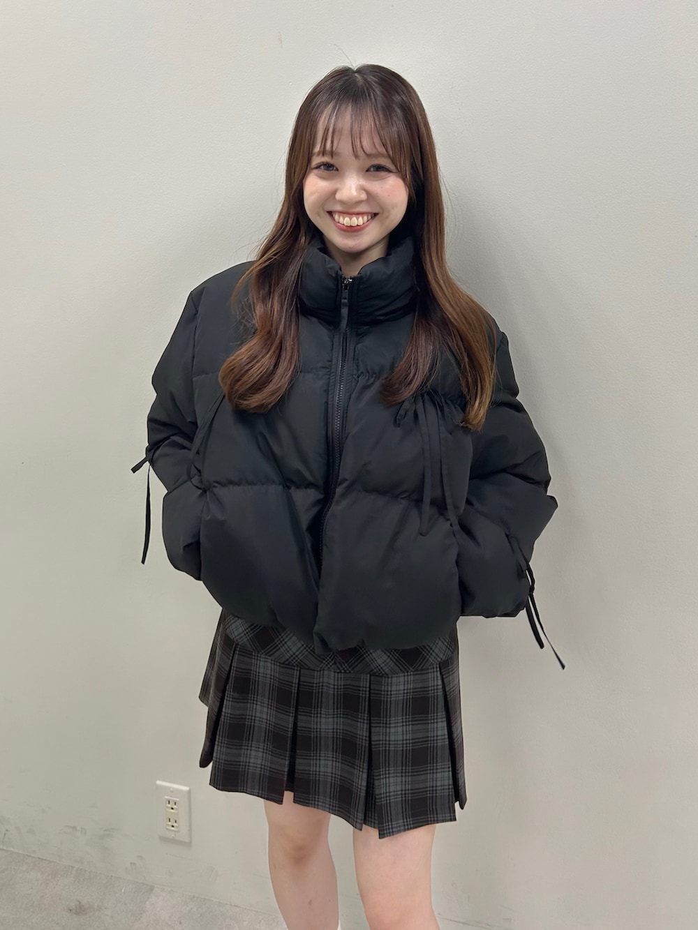 ブラック系のダウンジャケット/コート、グレー系のスカート、ベージュ系のブーツを着用したレディースの秋コーディネートの2枚目の写真