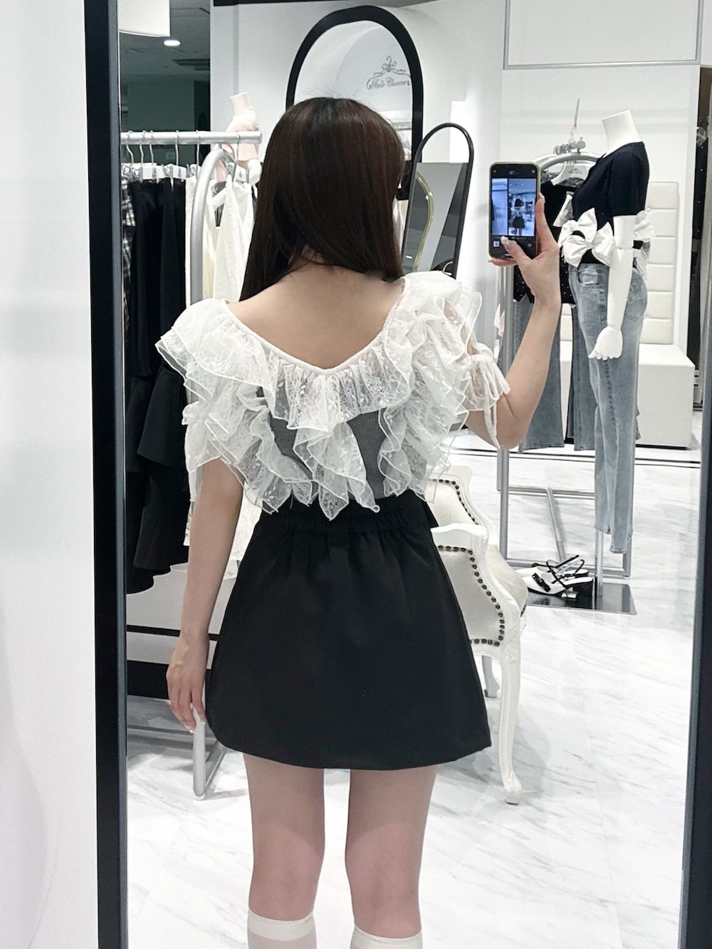グレー系のTシャツ/カットソー、ブラック系のスカート、ホワイト系のドレスシューズを着用したレディースの春コーディネートの6枚目の写真