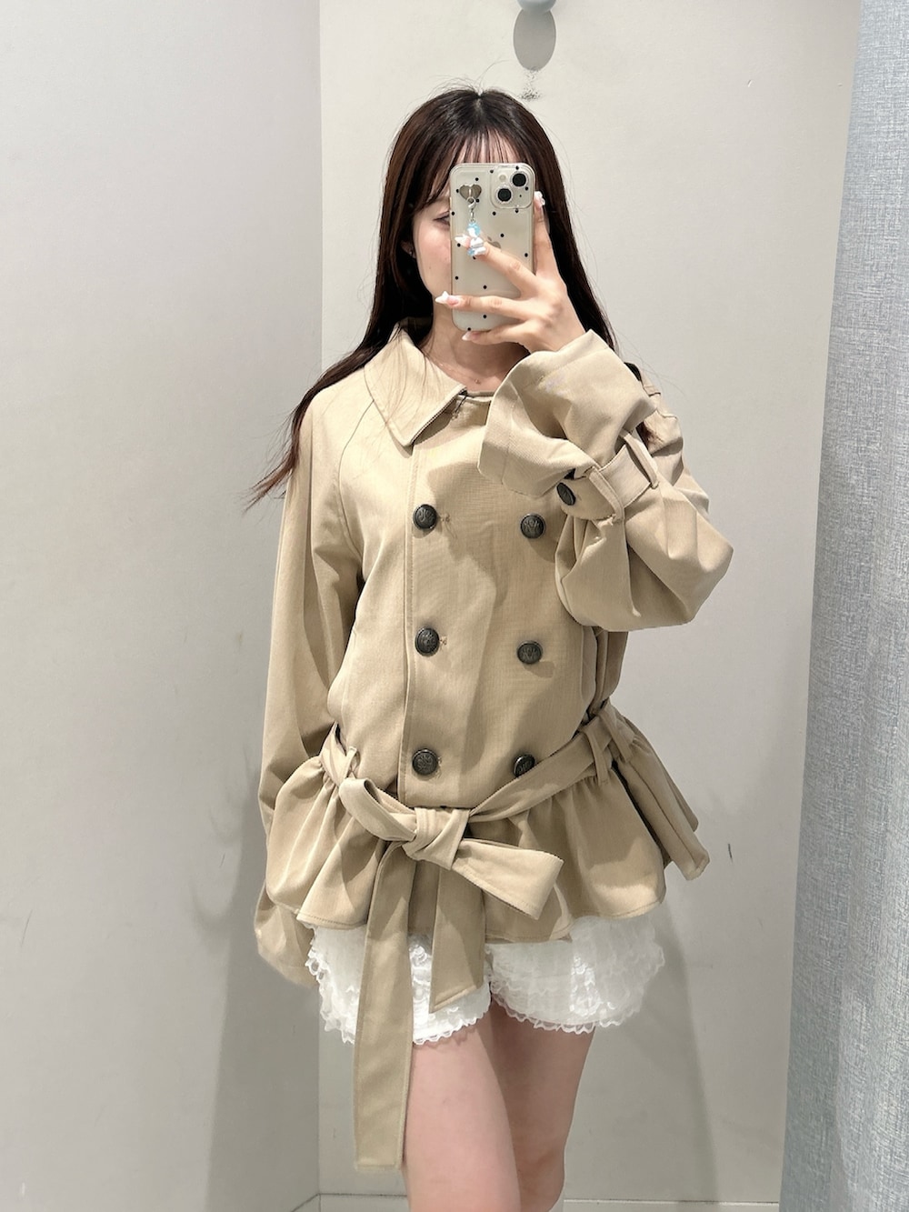 ベージュ系のトレンチコート、ホワイト系のその他パンツを着用したレディースの秋コーディネートの4枚目の写真