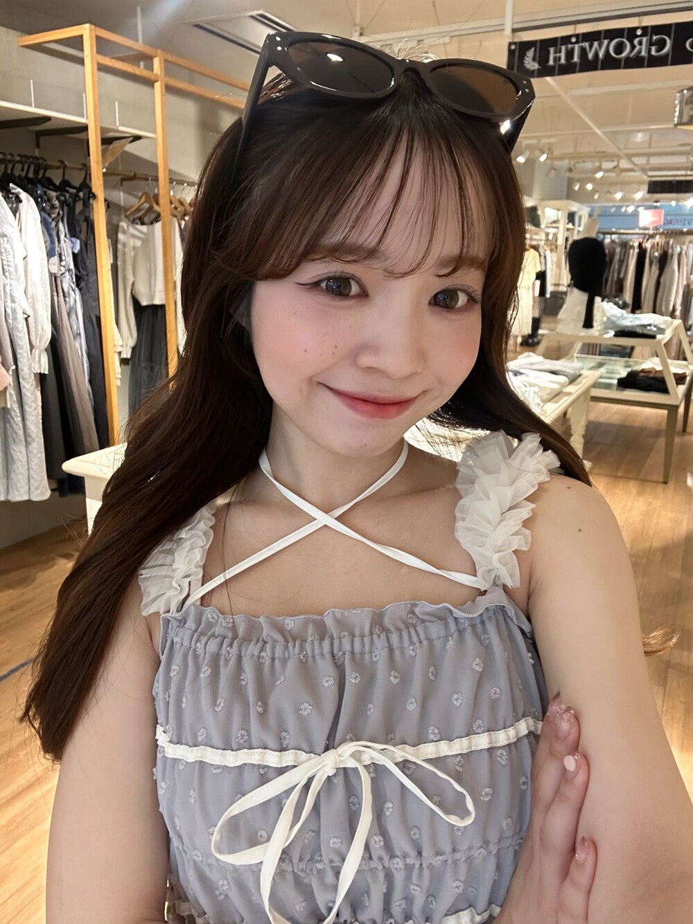 ホワイト系のショルダーバッグ、ブルー系のワンピース、ホワイト系のシューズを着用したレディースの春コーディネートの5枚目の写真