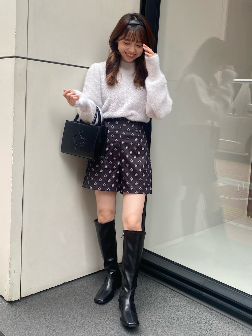 ブラック系のショルダーバッグ、ブラック系のパンツ、ブルー系のニット/セーターを着用したレディースの秋コーディネートの2枚目の写真