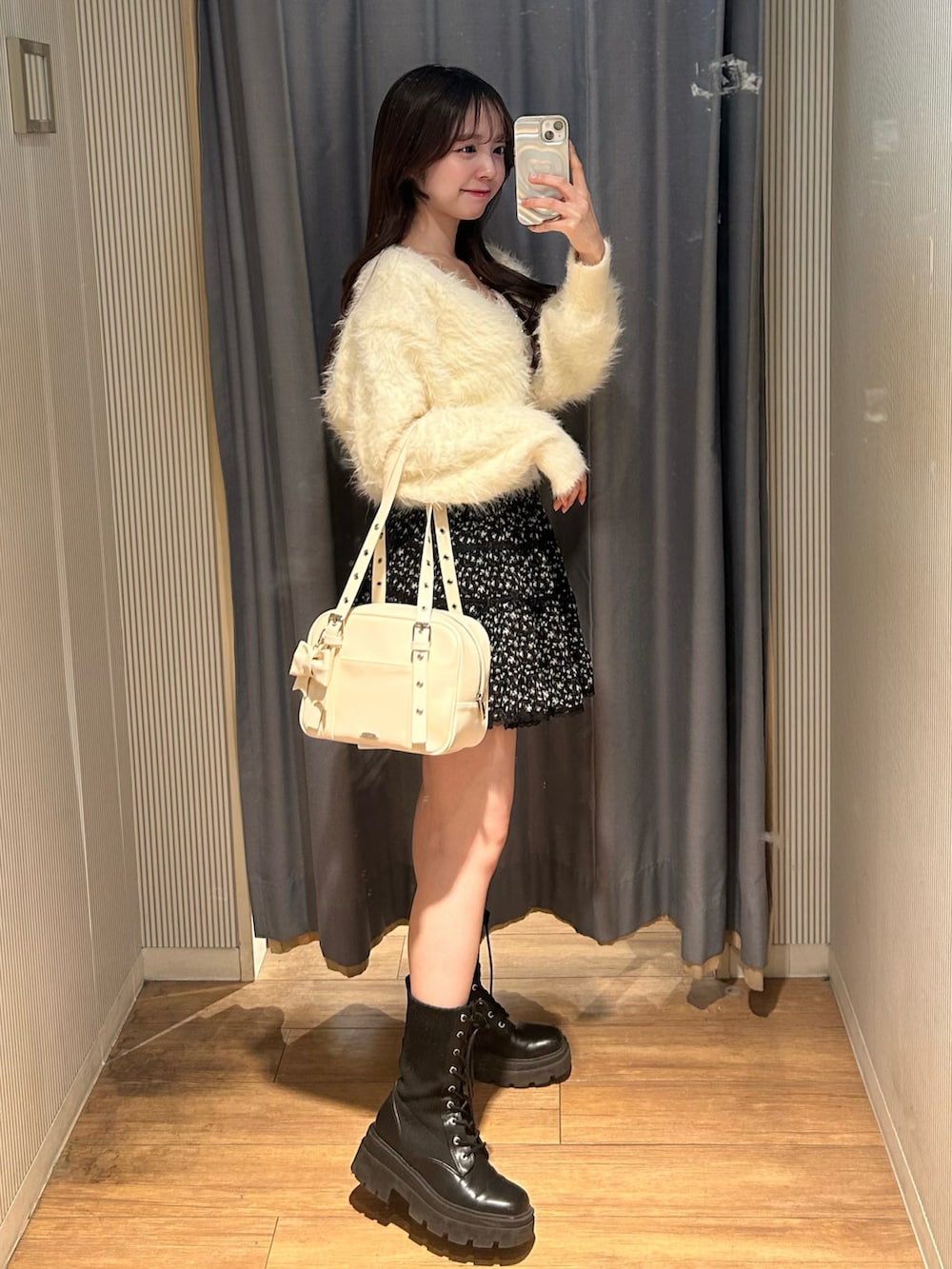 ホワイト系のショルダーバッグ、ホワイト系のカーディガン/ボレロ、その他のスカートを着用したレディースの冬コーディネートの2枚目の写真