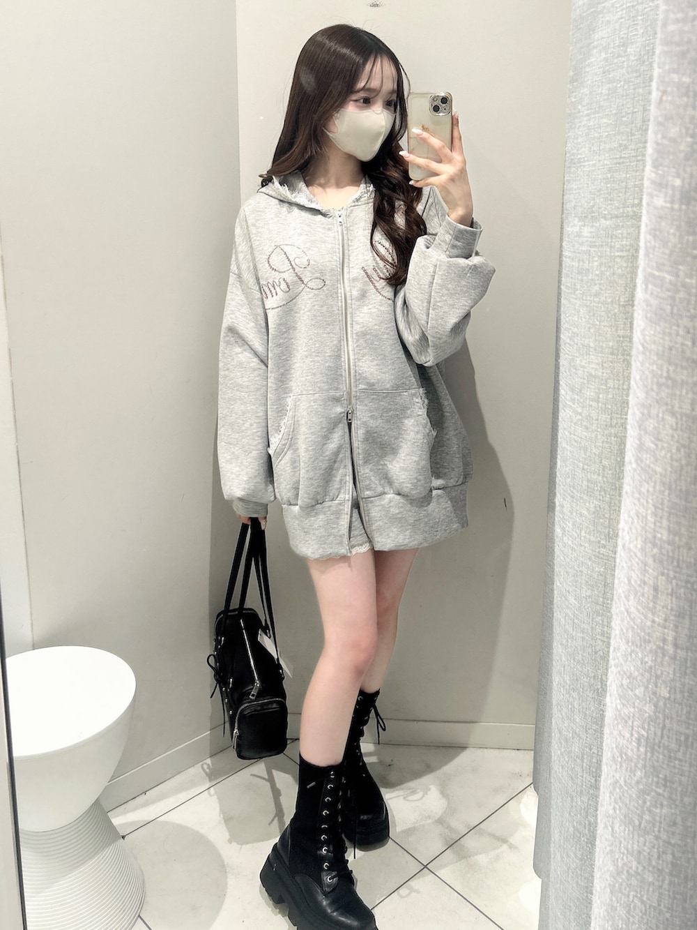 グレー系のパーカー、グレー系のその他パンツ、ブラック系のトートバッグを着用したレディースの冬コーディネートの2枚目の写真