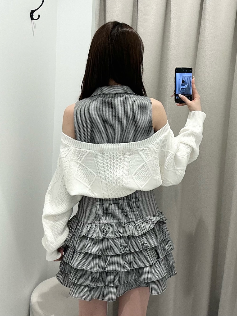 ブラック系のワンピース、ホワイト系のカーディガン/ボレロ、ブラック系のローファーを着用したレディースの春コーディネートの7枚目の写真