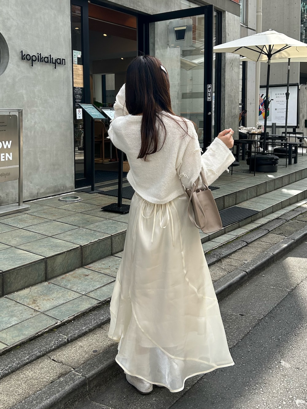 ホワイト系のスカート、ホワイト系のバレエシューズ、ホワイト系のニット/セーターを着用したレディースの秋コーディネートの5枚目の写真