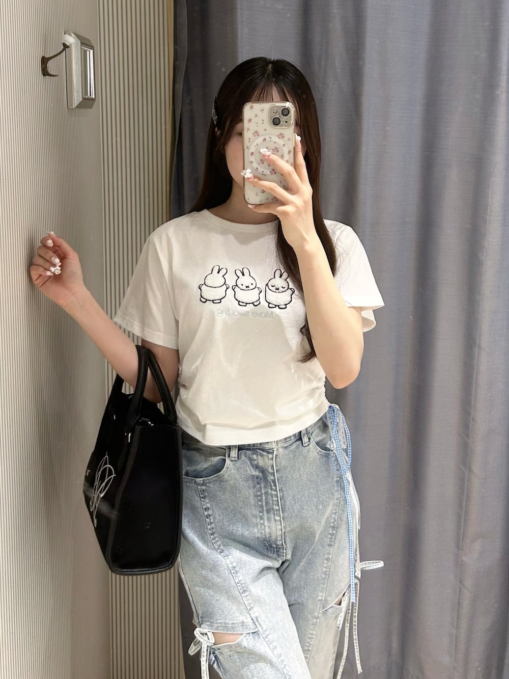 ホワイト系のTシャツ/カットソー、ブラック系のデニムパンツ、ブラック系のトートバッグを着用したレディースの春コーディネートの4枚目の写真