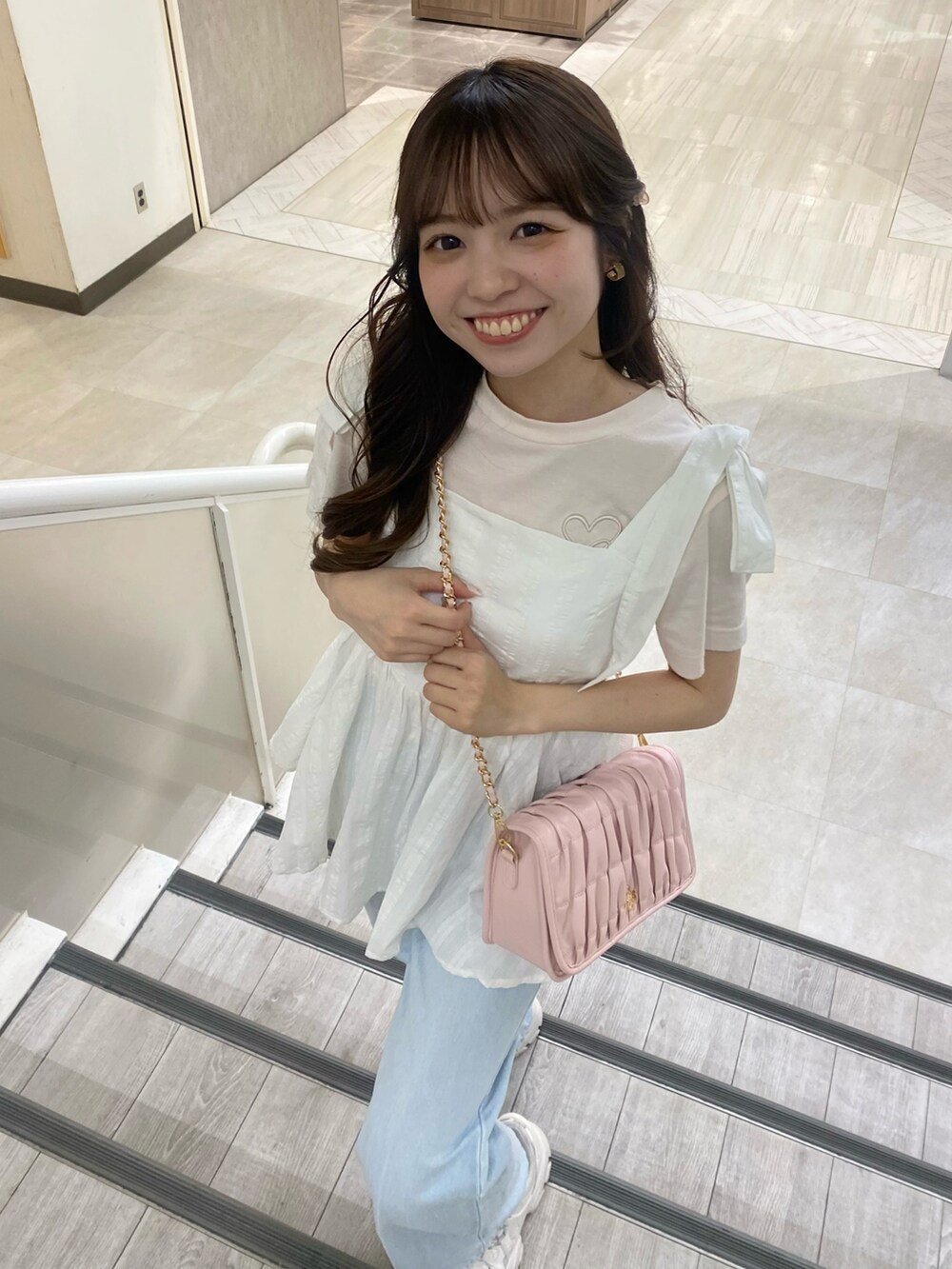 ホワイト系のスニーカー、ピンク系のショルダーバッグ、ホワイト系のTシャツ/カットソーを着用したレディースの夏コーディネートの3枚目の写真