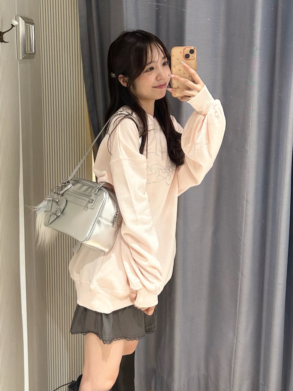 ピンク系のTシャツ/カットソー、グレー系のスカート、シルバー系のショルダーバッグを着用したレディースの秋コーディネートの2枚目の写真