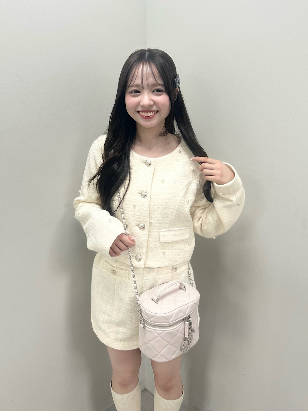 ホワイト系のノーカラージャケット、ホワイト系のブーツ、ホワイト系のショルダーバッグを着用したレディースの春コーディネートの9枚目の写真