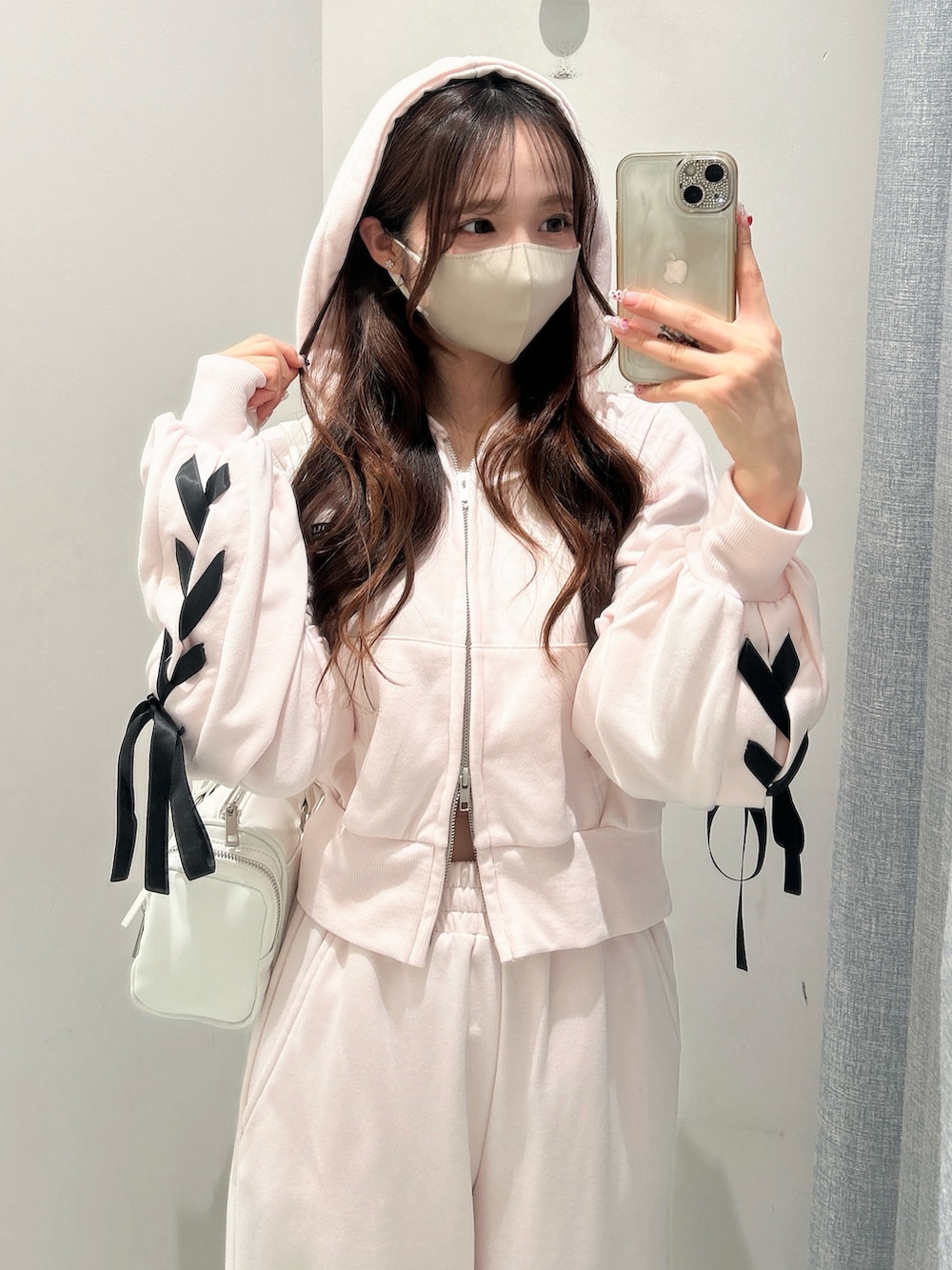 ホワイト系のスニーカー、ピンク系のスウェットパンツ、ピンク系のパーカーを着用したレディースの冬コーディネートの7枚目の写真