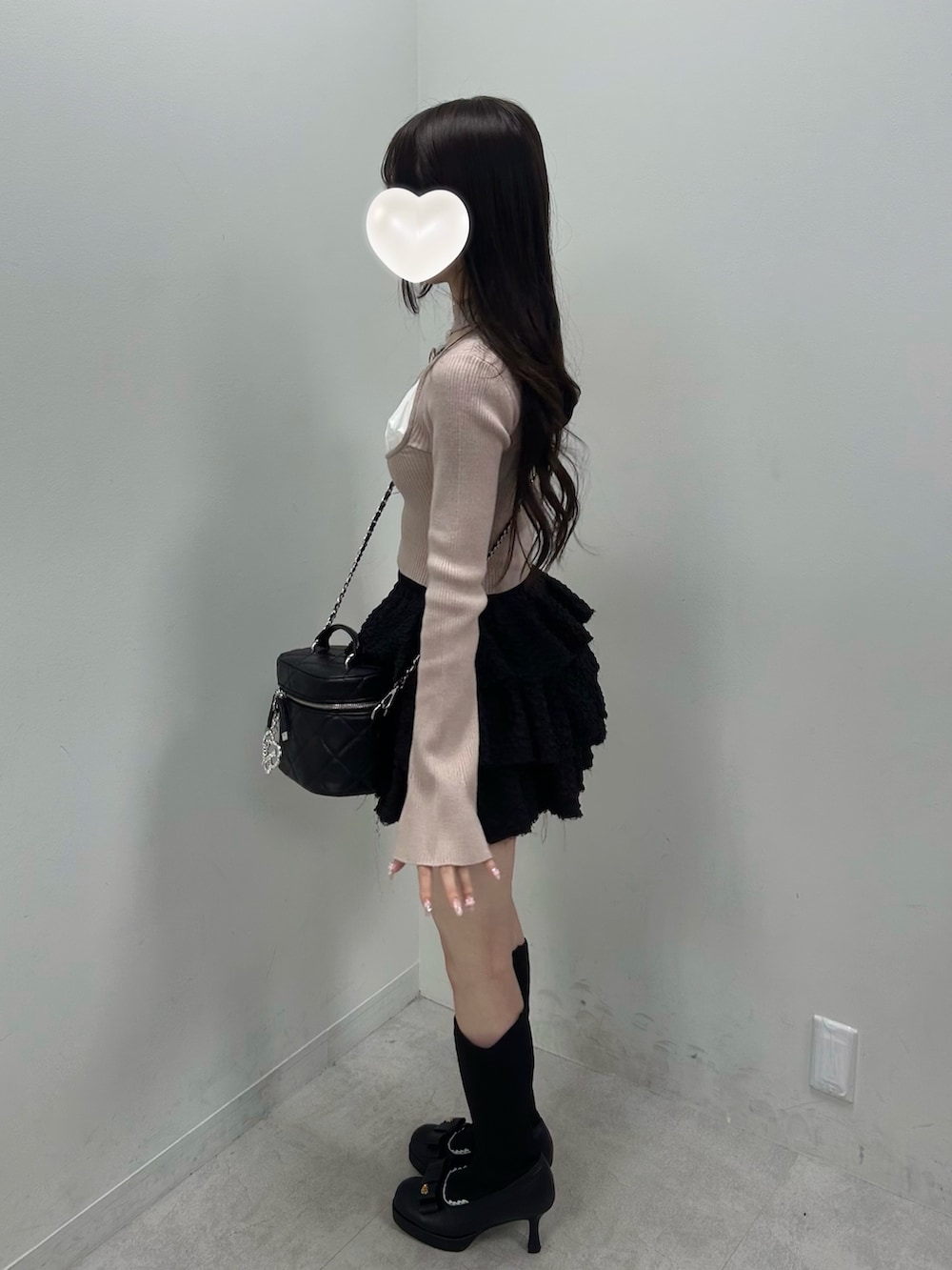 ベージュ系のニット/セーター、ブラック系のスカート、ブラック系のショルダーバッグを着用したレディースの春コーディネートの5枚目の写真
