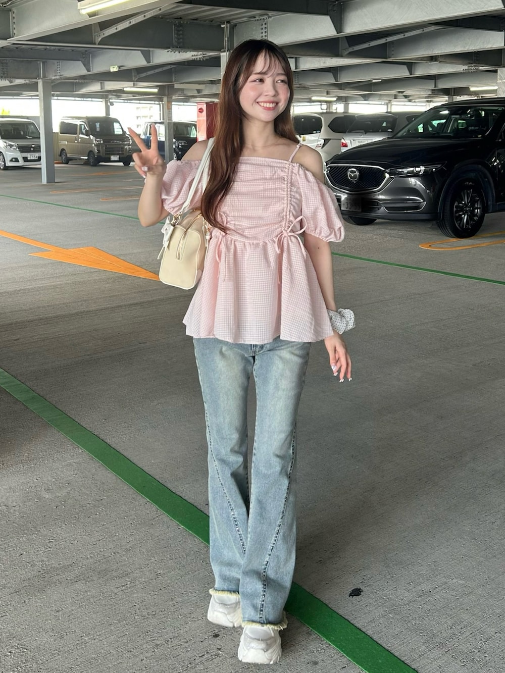 ピンク系のシャツ/ブラウス、ブルー系のデニムパンツ、ホワイト系のスニーカーを着用したレディースの夏コーディネートの2枚目の写真