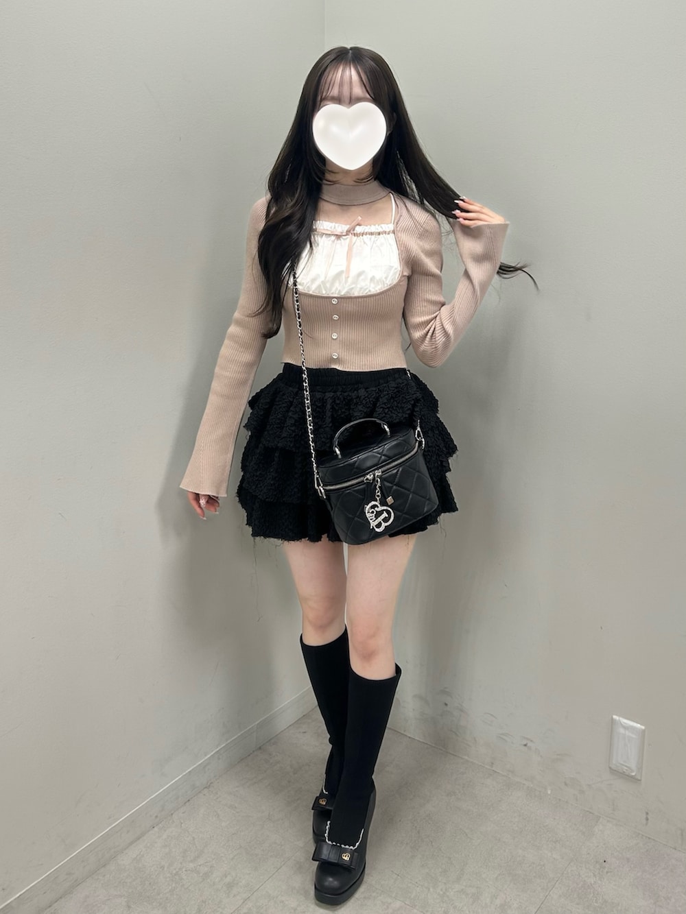 ベージュ系のニット/セーター、ブラック系のスカート、ブラック系のショルダーバッグを着用したレディースの春コーディネートの3枚目の写真