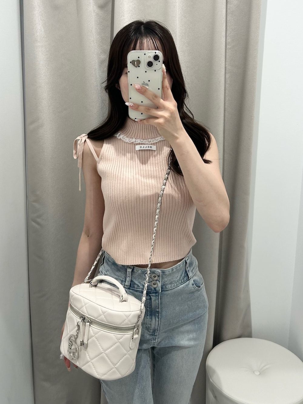 ピンク系のアンサンブル、ホワイト系のショルダーバッグ、ブルー系のデニムパンツを着用したレディースの夏コーディネートの4枚目の写真