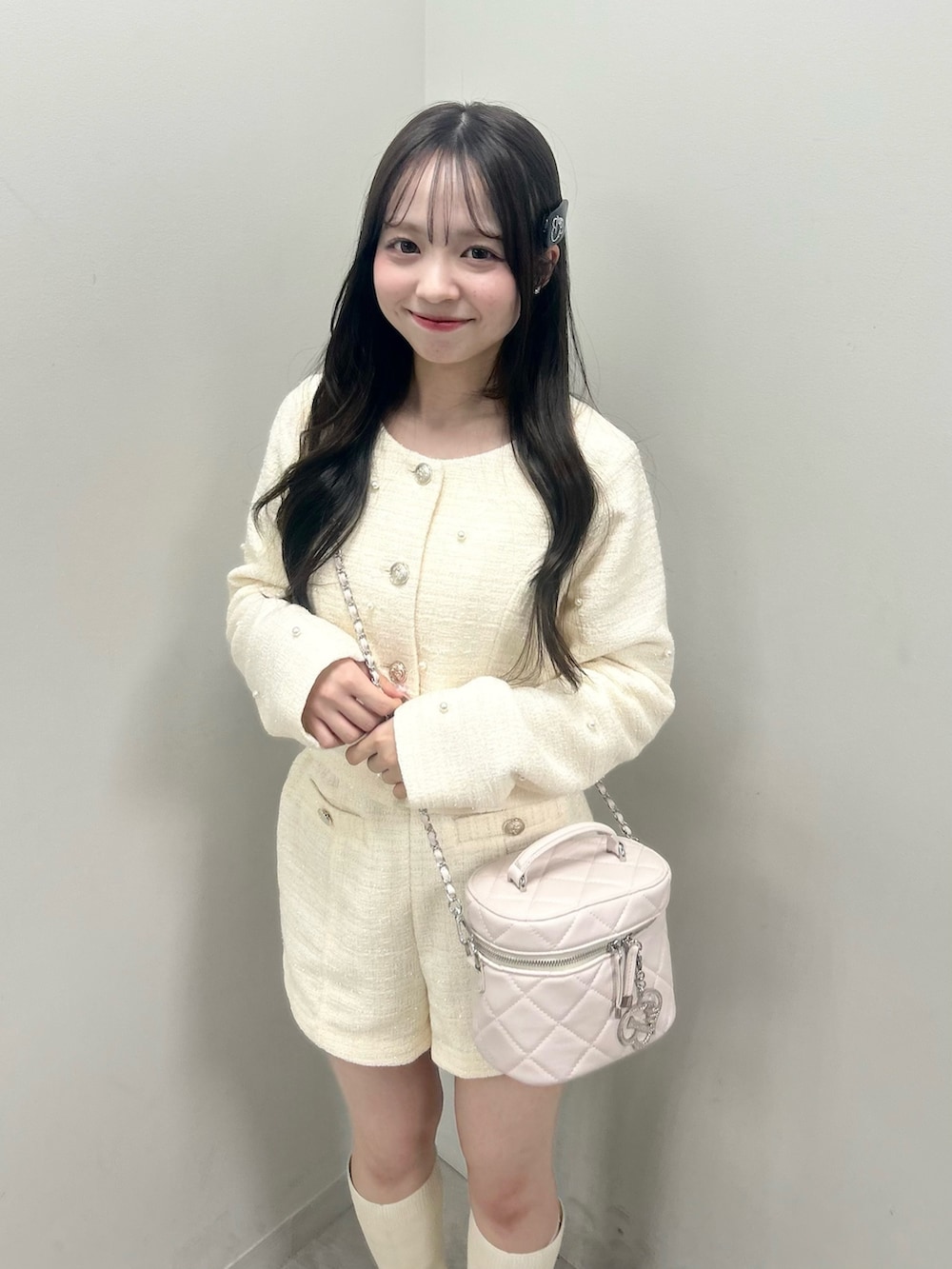 ホワイト系のノーカラージャケット、ホワイト系のブーツ、ホワイト系のショルダーバッグを着用したレディースの春コーディネートの5枚目の写真