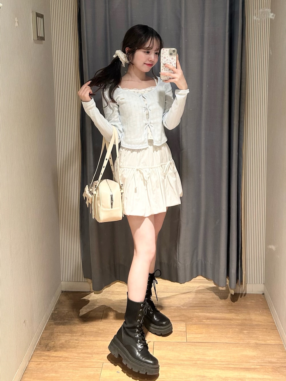 ホワイト系のショルダーバッグ、ホワイト系のスカート、ブルー系のTシャツ/カットソーを着用したレディースの春コーディネートの3枚目の写真