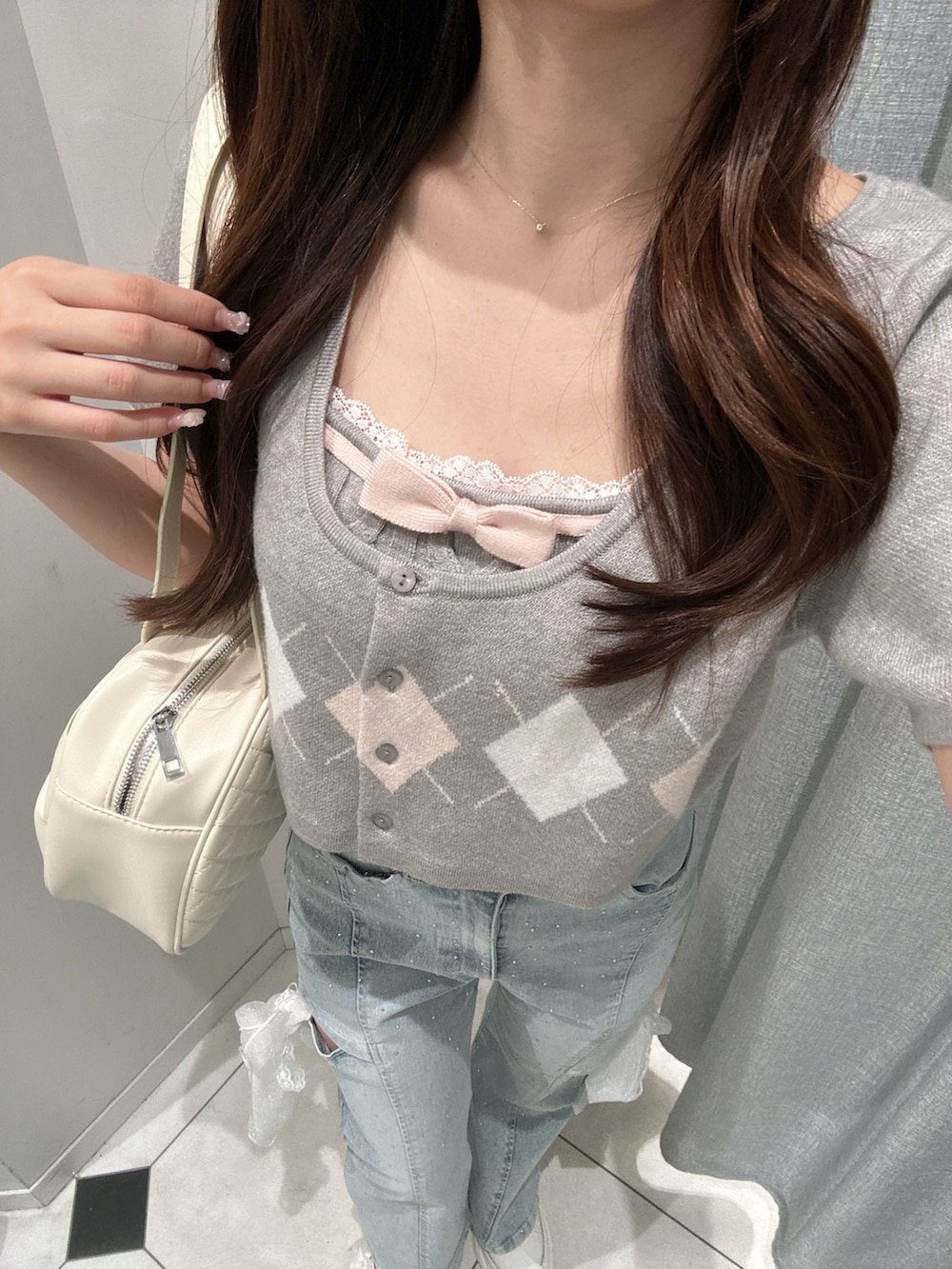 グレー系のアンサンブル、ホワイト系のスニーカー、ブルー系のデニムパンツを着用したレディースの夏コーディネートの6枚目の写真