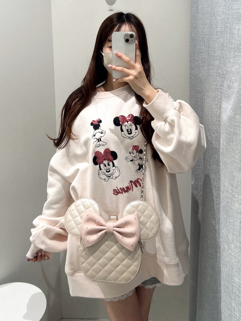 ピンク系のスウェット、ピンク系のショルダーバッグを着用したレディースの冬コーディネートの6枚目の写真