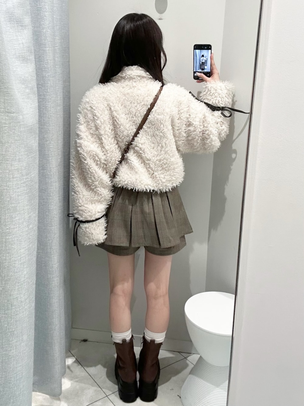 ブラウン系のブーツ、ブラウン系のショルダーバッグ、ブラウン系のスカートを着用したレディースの秋コーディネートの6枚目の写真