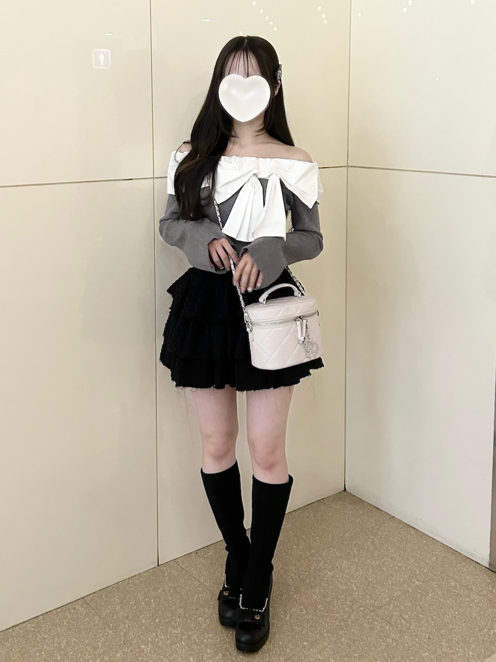 グレー系のニット/セーター、ホワイト系のショルダーバッグ、ブラック系のスカートを着用したレディースの冬コーディネートの8枚目の写真