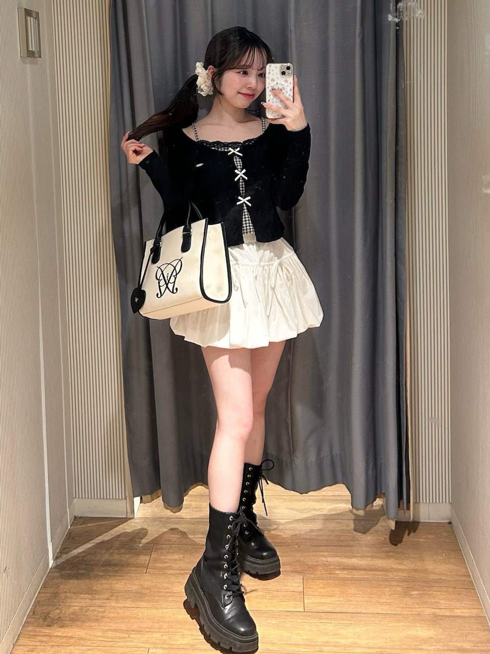 ホワイト系のトートバッグ、ブラック系のTシャツ/カットソー、ホワイト系のスカートを着用したレディースの春コーディネートの3枚目の写真