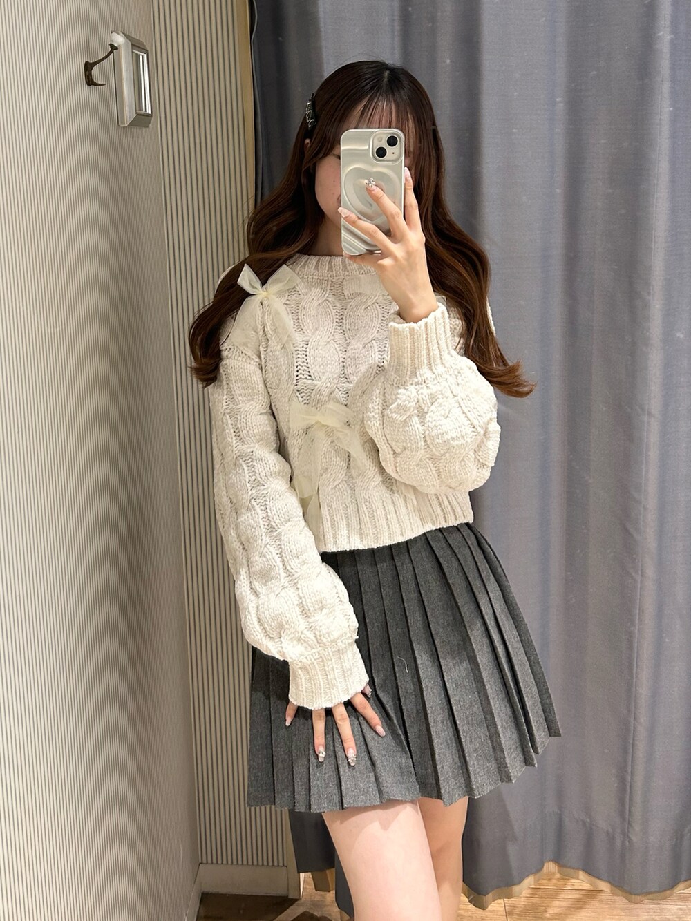 グレー系のスカート、ホワイト系のニット/セーターを着用したレディースの秋コーディネートの4枚目の写真