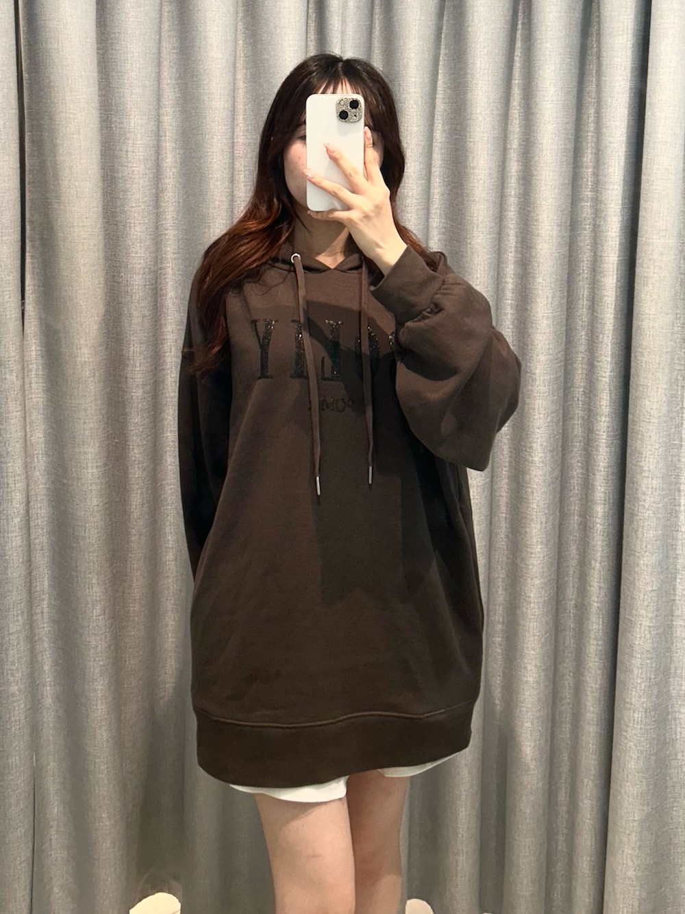 ブラック系のパーカー、ホワイト系のスカートを着用したレディースの秋コーディネートの3枚目の写真