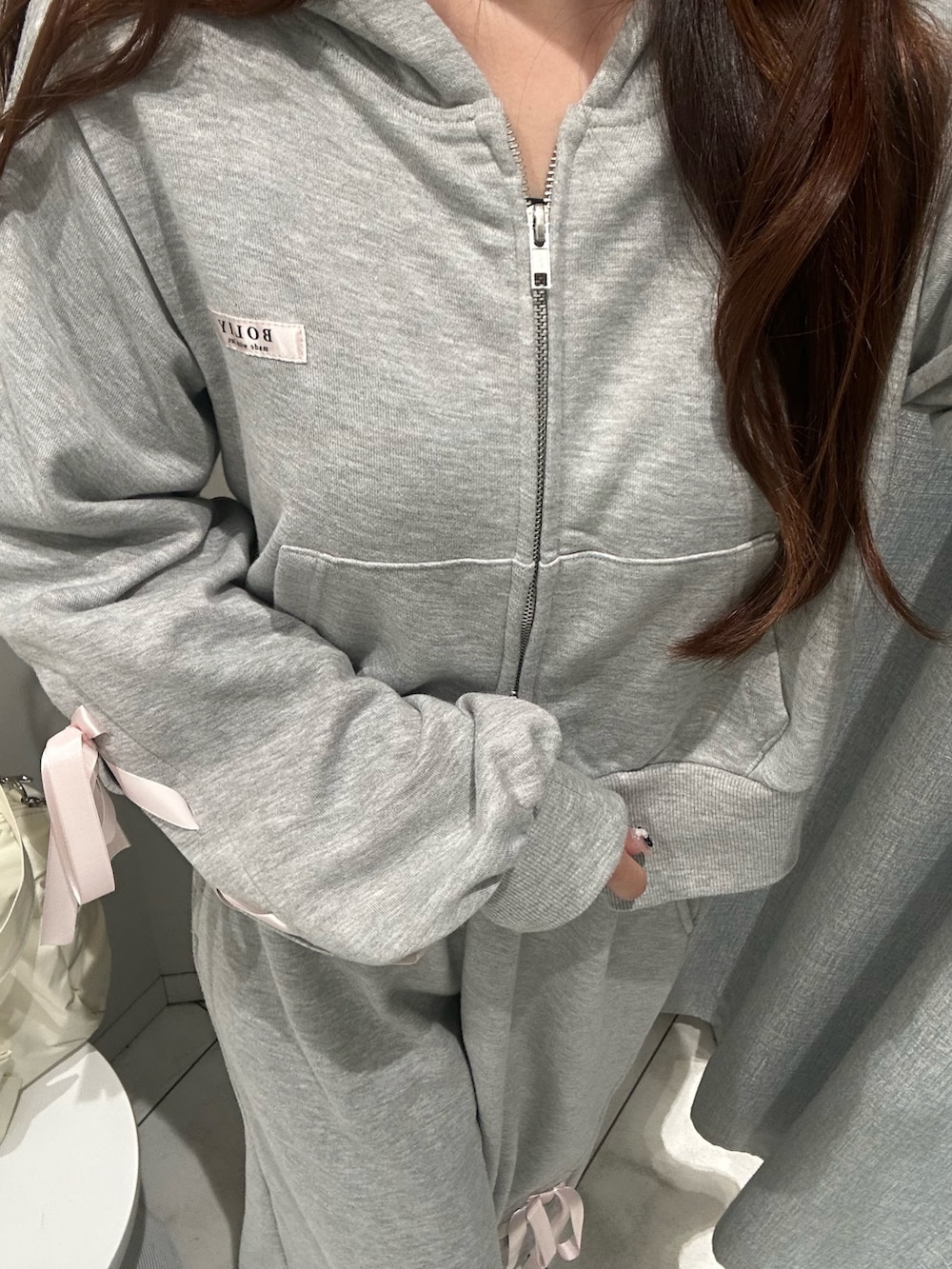 グレー系のスウェットパンツ、グレー系のパーカー、イエロー系のボストンバッグを着用したレディースの冬コーディネートの6枚目の写真