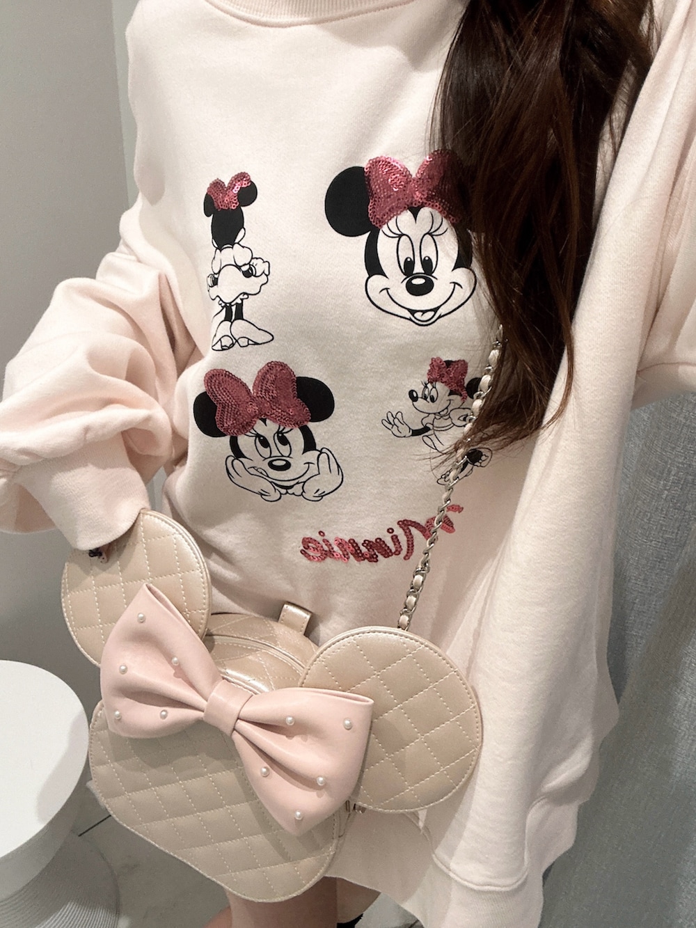 ピンク系のスウェット、ピンク系のショルダーバッグを着用したレディースの冬コーディネートの3枚目の写真