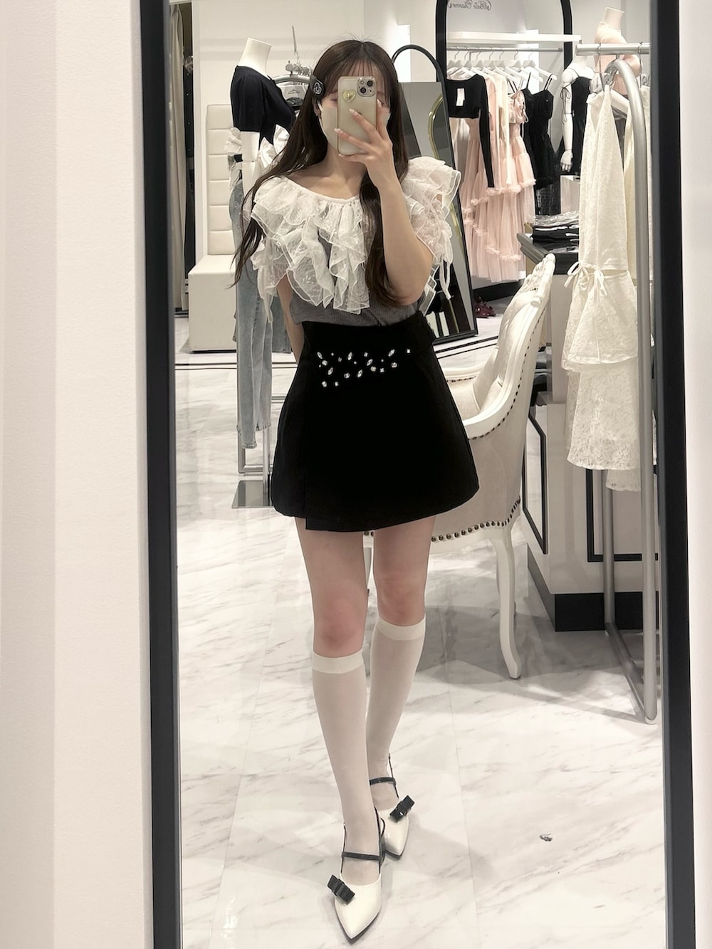 グレー系のTシャツ/カットソー、ブラック系のスカート、ホワイト系のドレスシューズを着用したレディースの春コーディネートの2枚目の写真