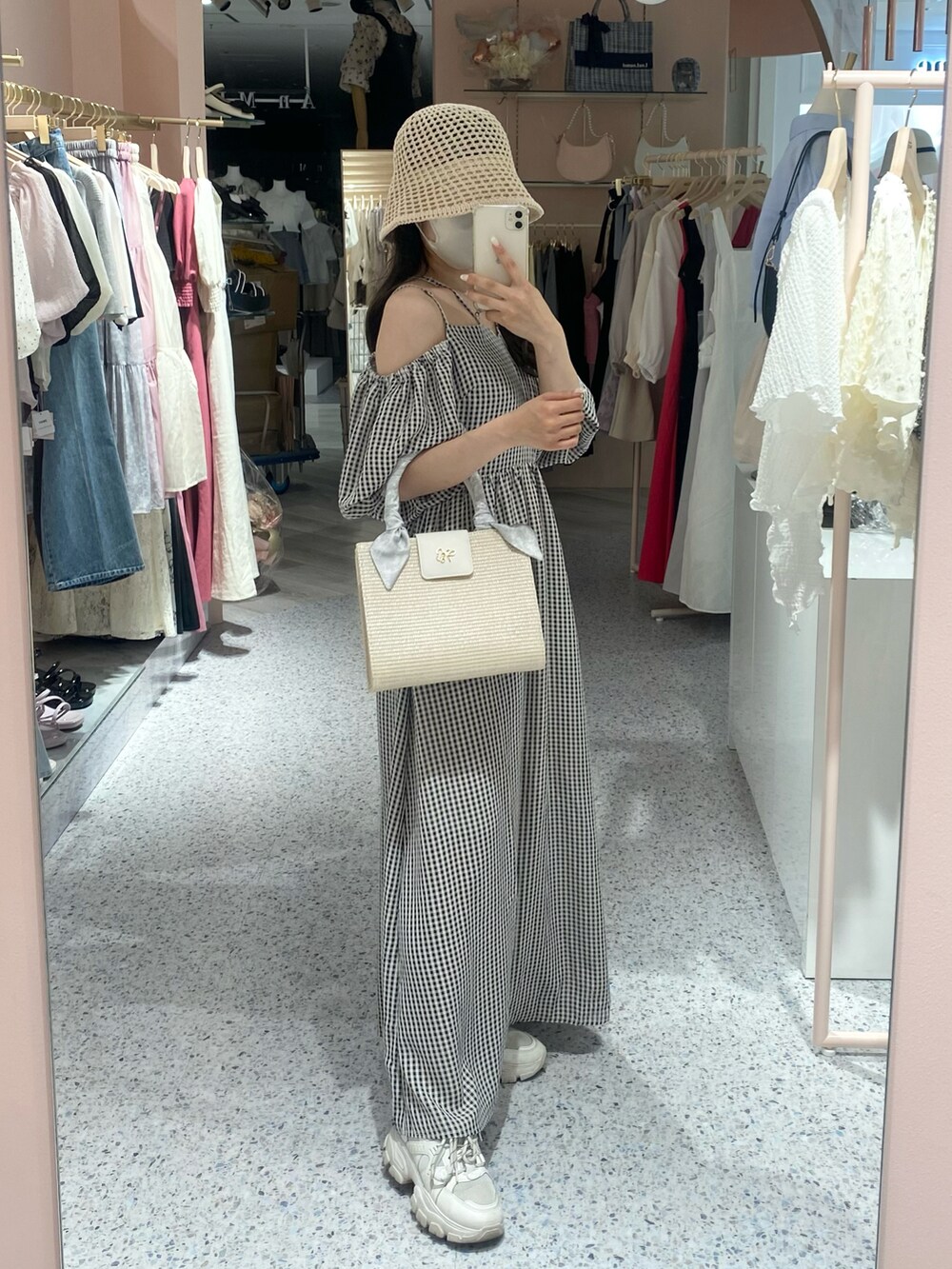 ホワイト系のショルダーバッグ、ホワイト系のスニーカー、ブラック系のワンピースを着用したレディースの夏コーディネートの2枚目の写真