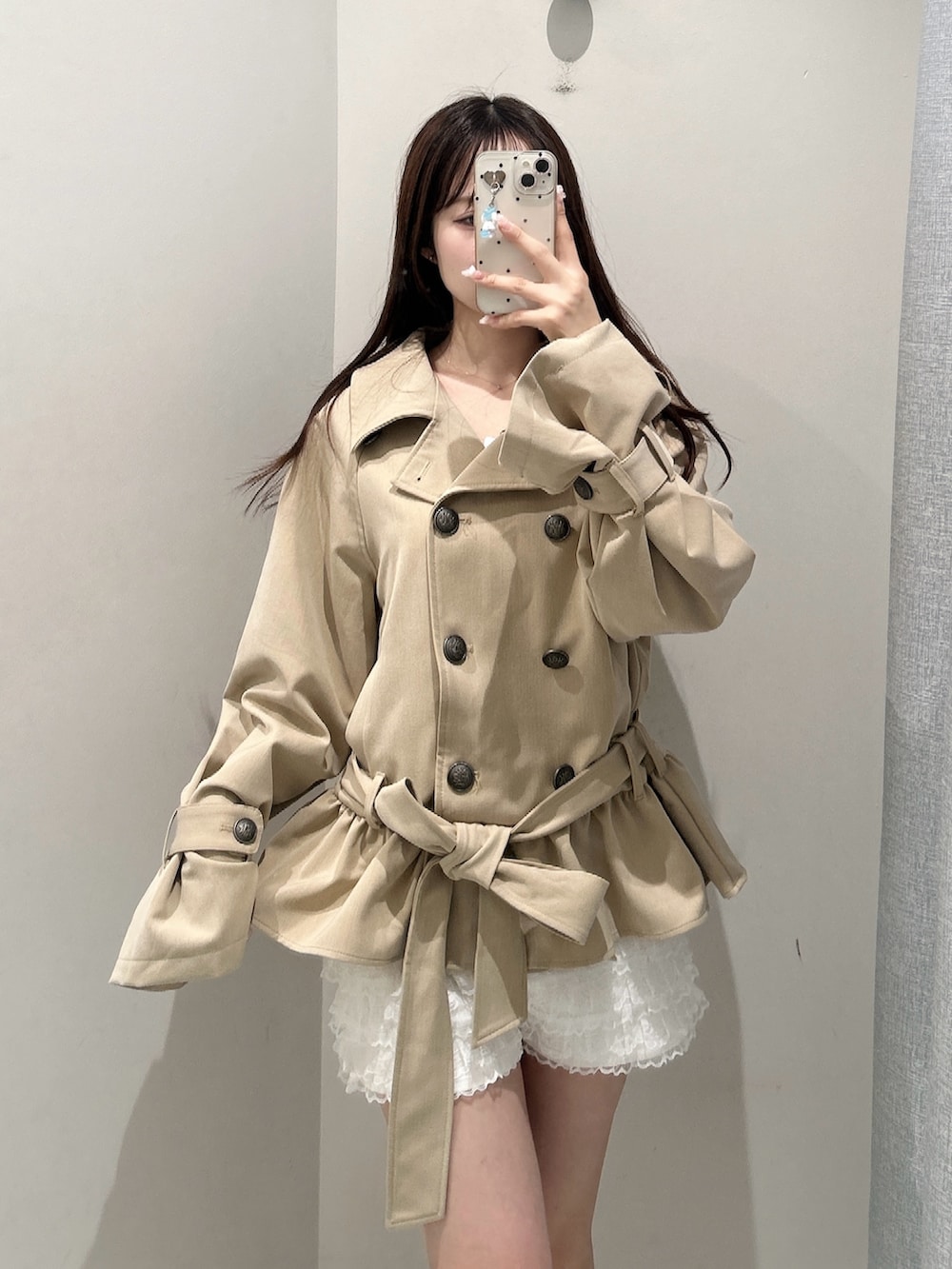 ベージュ系のトレンチコート、ホワイト系のその他パンツを着用したレディースの秋コーディネートの3枚目の写真
