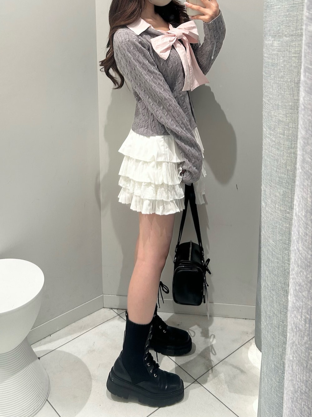 ブラック系のトートバッグ、ホワイト系のスカート、グレー系のニット/セーターを着用したレディースの冬コーディネートの4枚目の写真