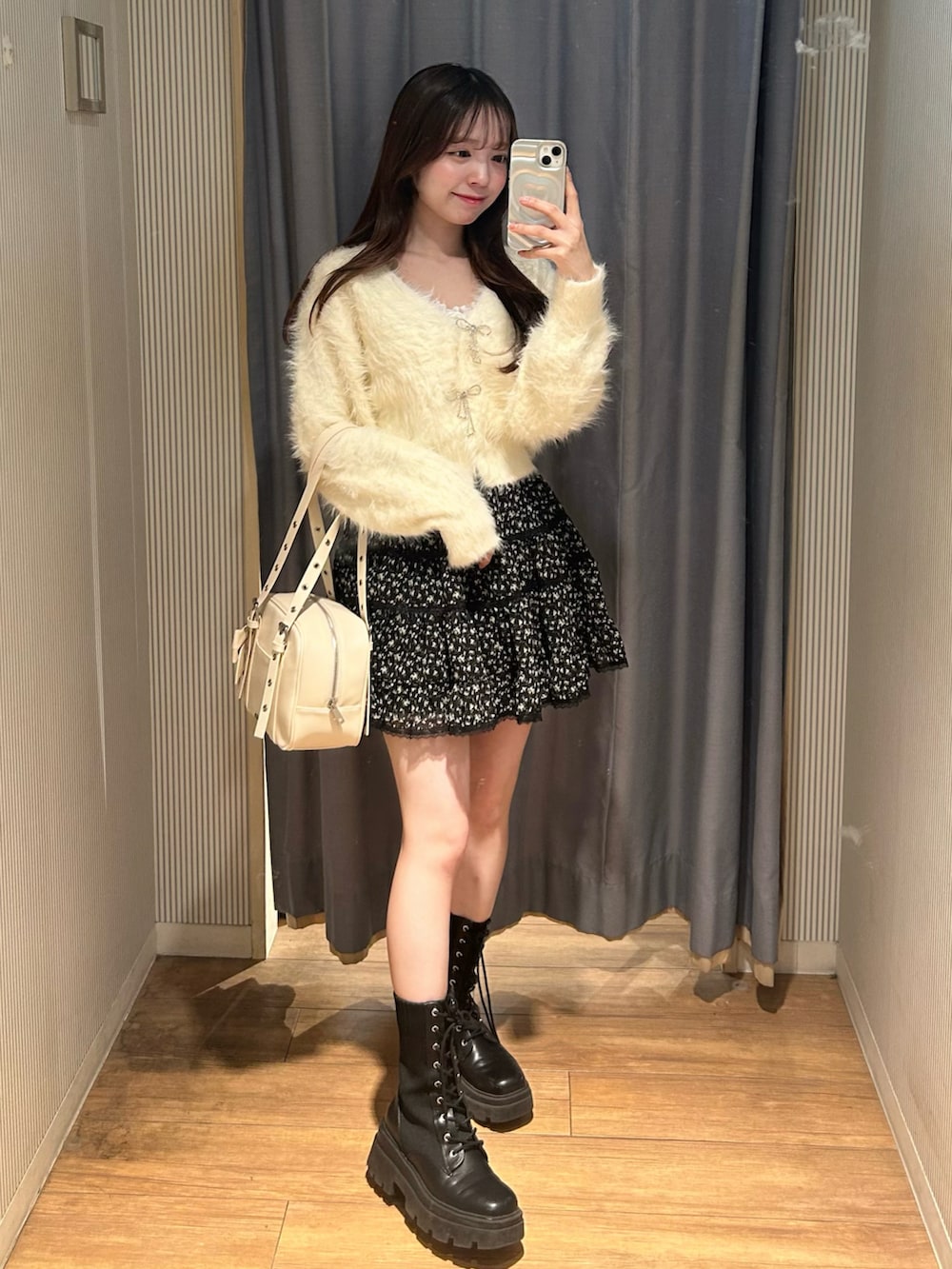 ホワイト系のショルダーバッグ、その他のスカート、ホワイト系のカーディガン/ボレロを着用したレディースの冬コーディネートの2枚目の写真