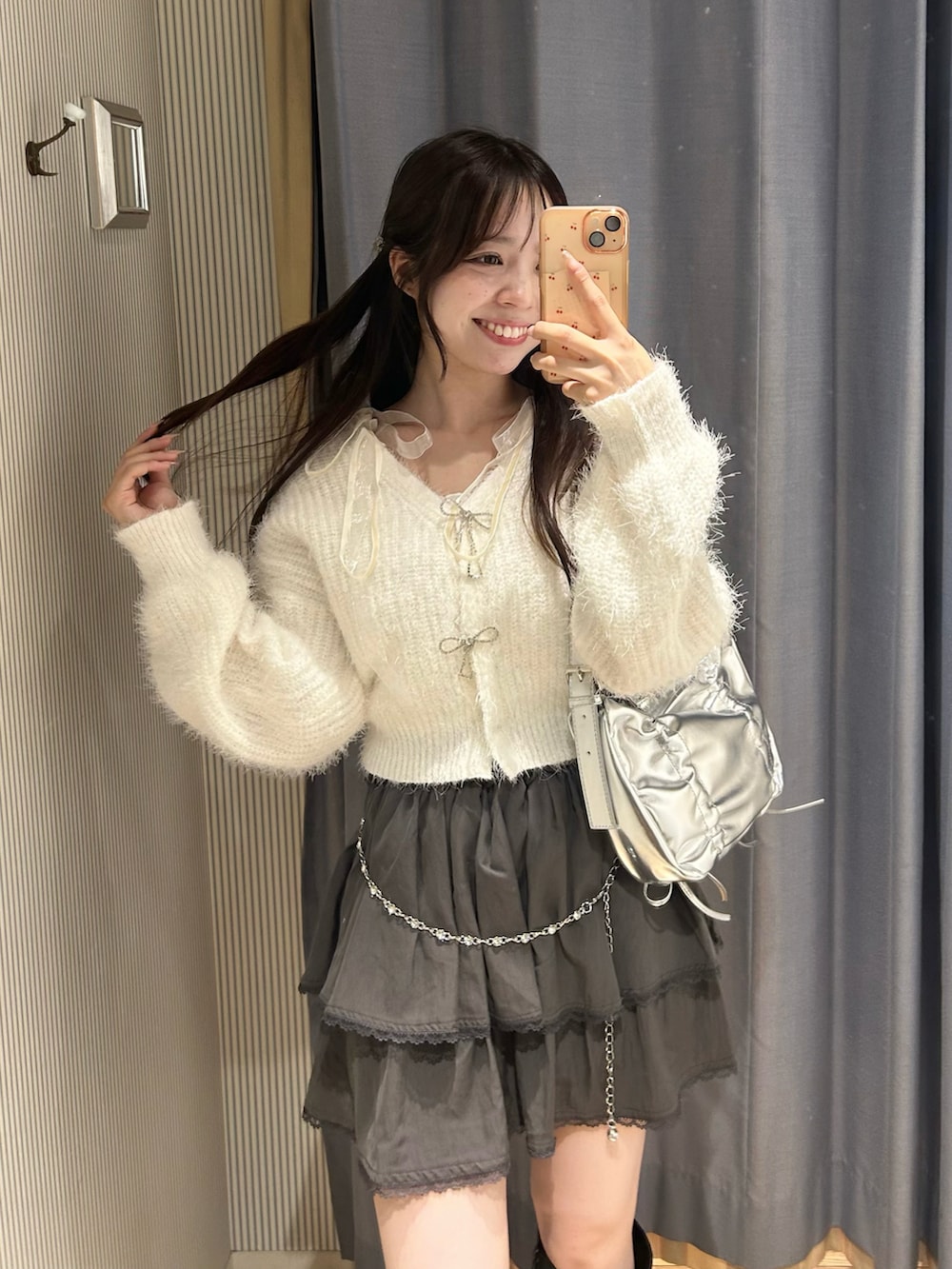 ホワイト系のカーディガン/ボレロ、シルバー系のショルダーバッグ、グレー系のスカートを着用したレディースの秋コーディネートの4枚目の写真