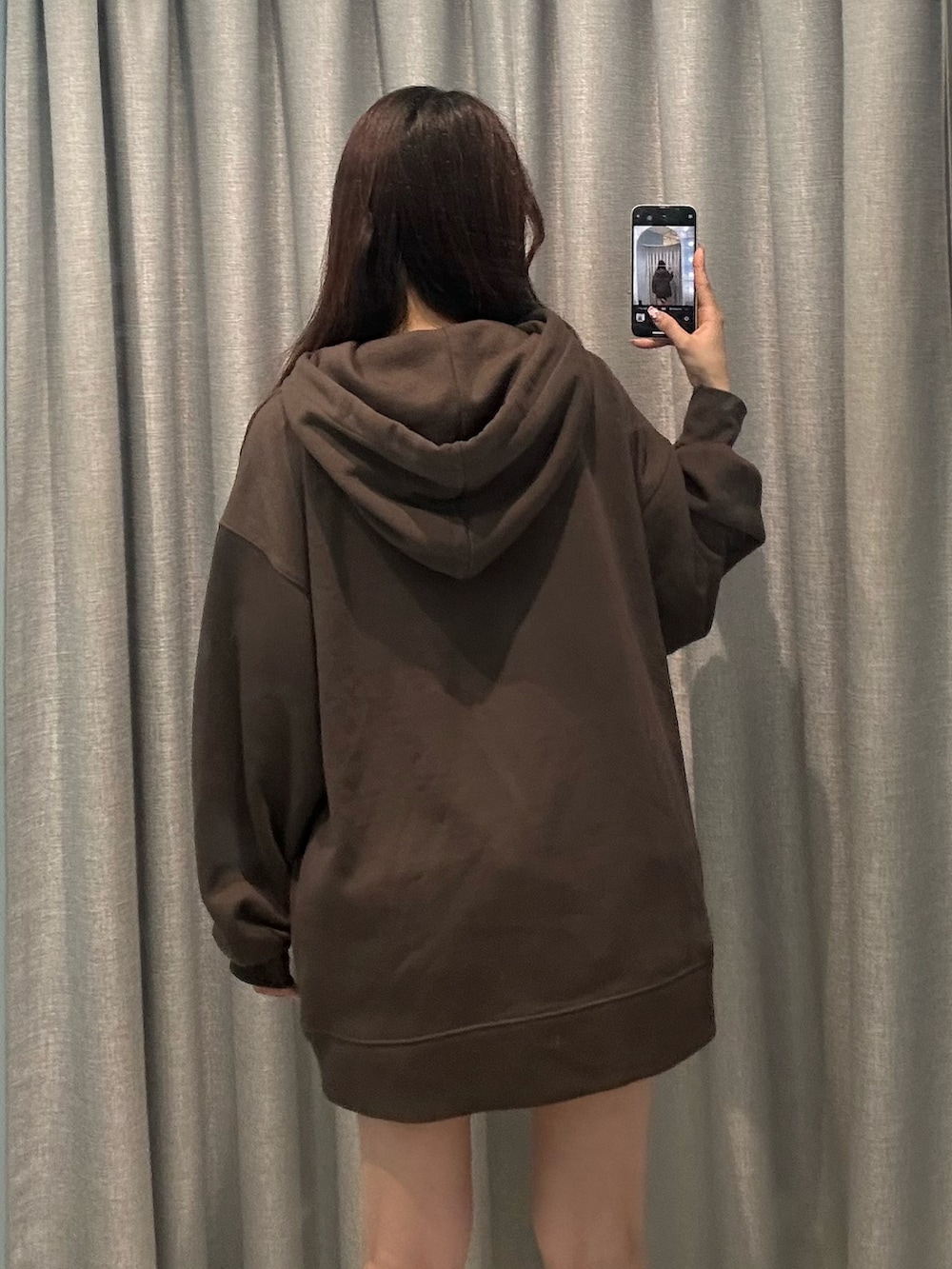 ブラック系のパーカー、ホワイト系のスカートを着用したレディースの秋コーディネートの4枚目の写真