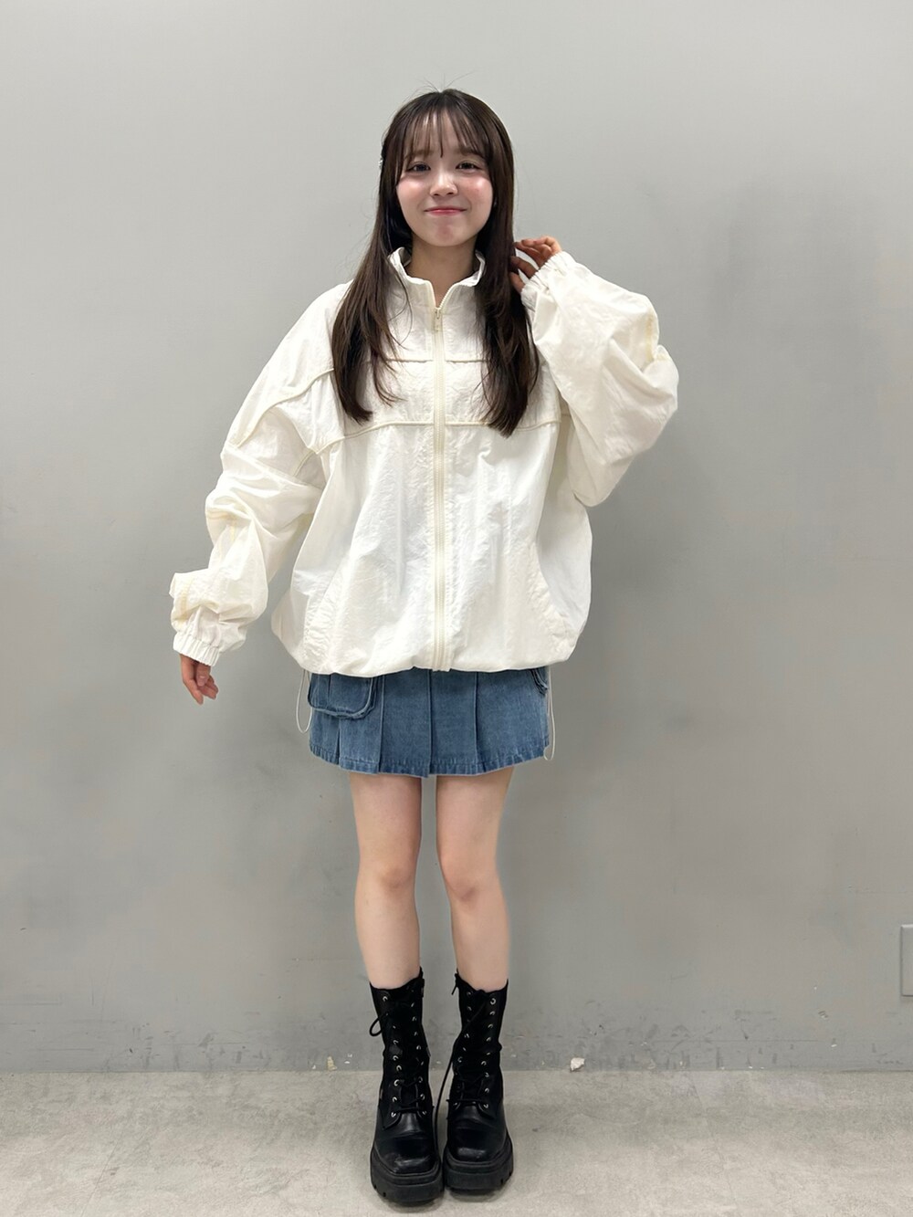 ブルー系のスカート、ホワイト系のブルゾンを着用したレディースの冬コーディネートの2枚目の写真