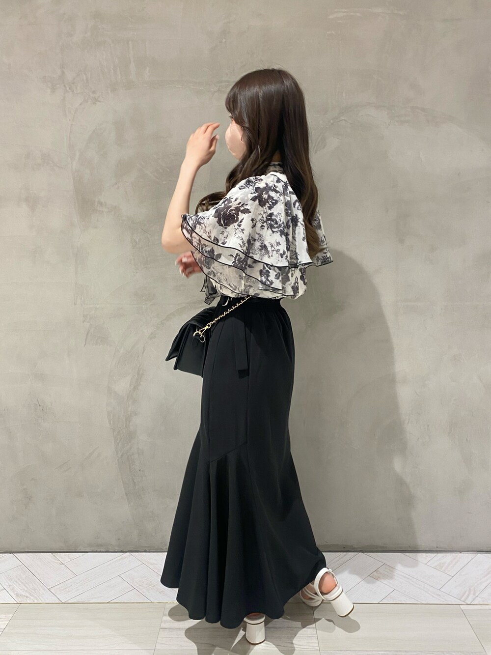 ホワイト系のシャツ/ブラウス、ブラック系のスカート、ホワイト系のショルダーバッグを着用したレディースの夏コーディネートの2枚目の写真