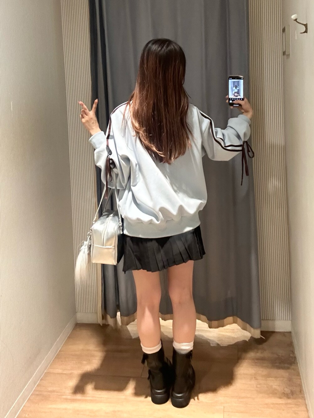 ブラック系のスカート、ブルー系のジャージ、ブラック系のブーツを着用したレディースの秋コーディネートの5枚目の写真