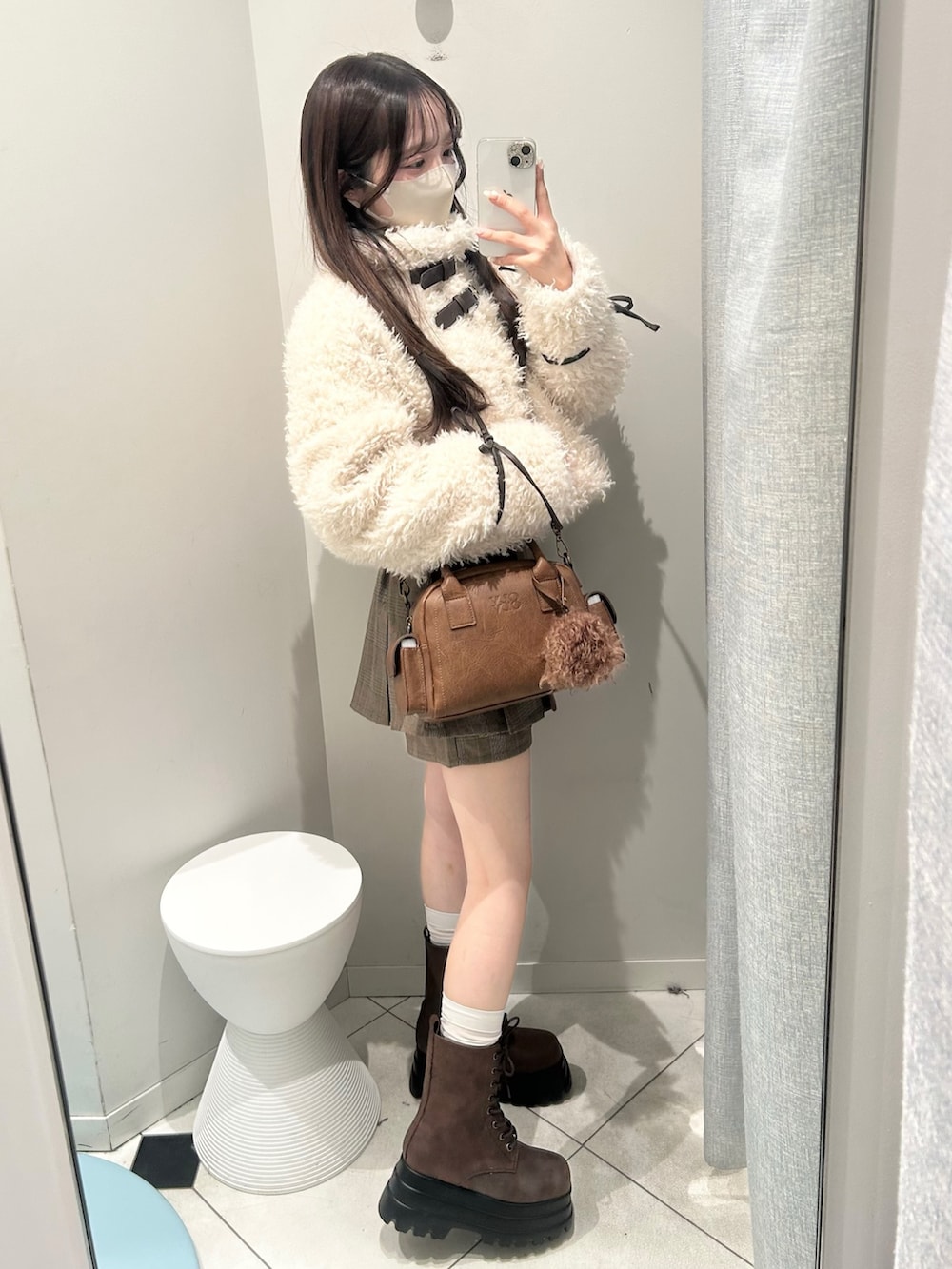 ブラウン系のブーツ、ブラウン系のショルダーバッグ、ブラウン系のスカートを着用したレディースの秋コーディネートの3枚目の写真