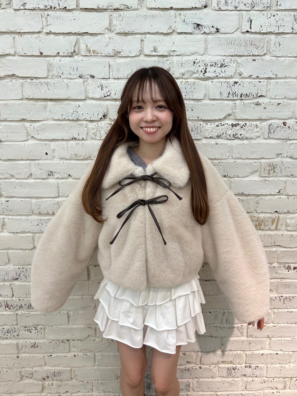 ベージュ系のブルゾン、ホワイト系のスカート、ブラック系のブーツを着用したレディースの秋コーディネートの4枚目の写真