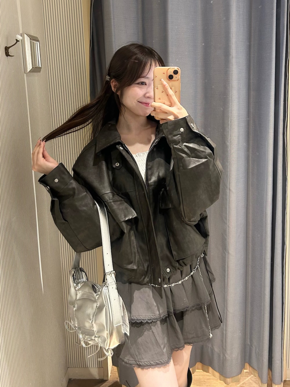 ブラック系のブルゾン、グレー系のスカート、ブラック系のブーツを着用したレディースの秋コーディネートの3枚目の写真