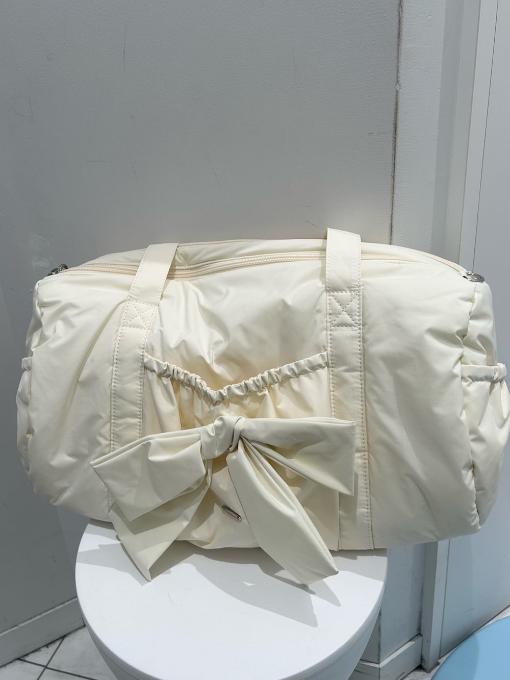 グレー系のスウェットパンツ、グレー系のパーカー、イエロー系のボストンバッグを着用したレディースの冬コーディネートの7枚目の写真